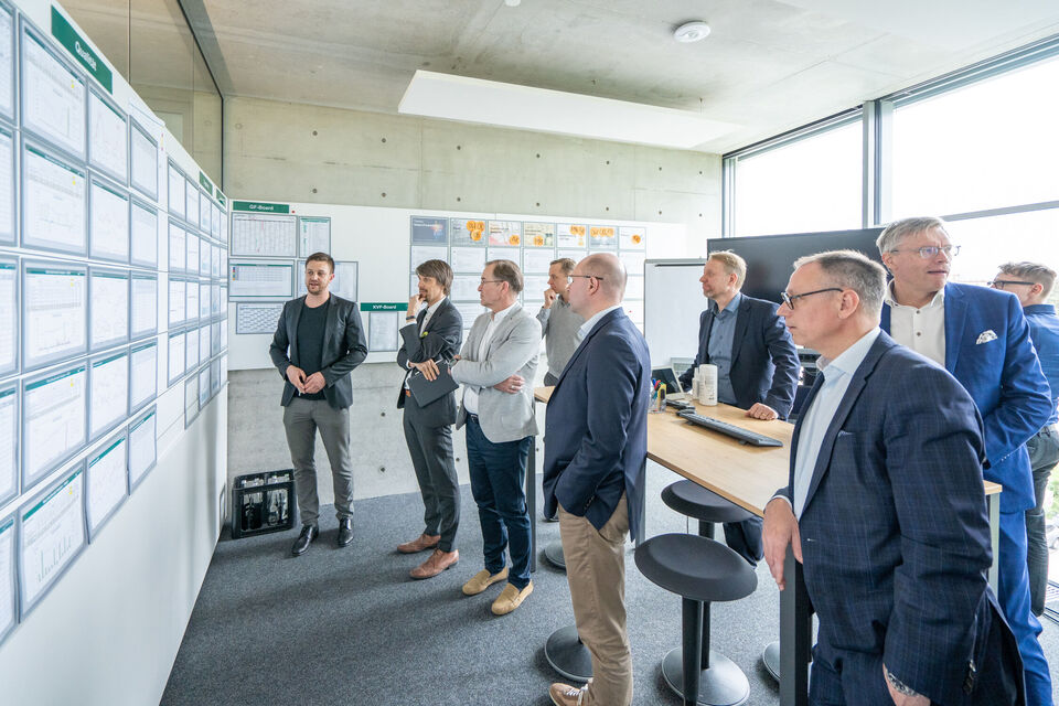 Eine Gruppe von Männern steht vor einem Wideboard