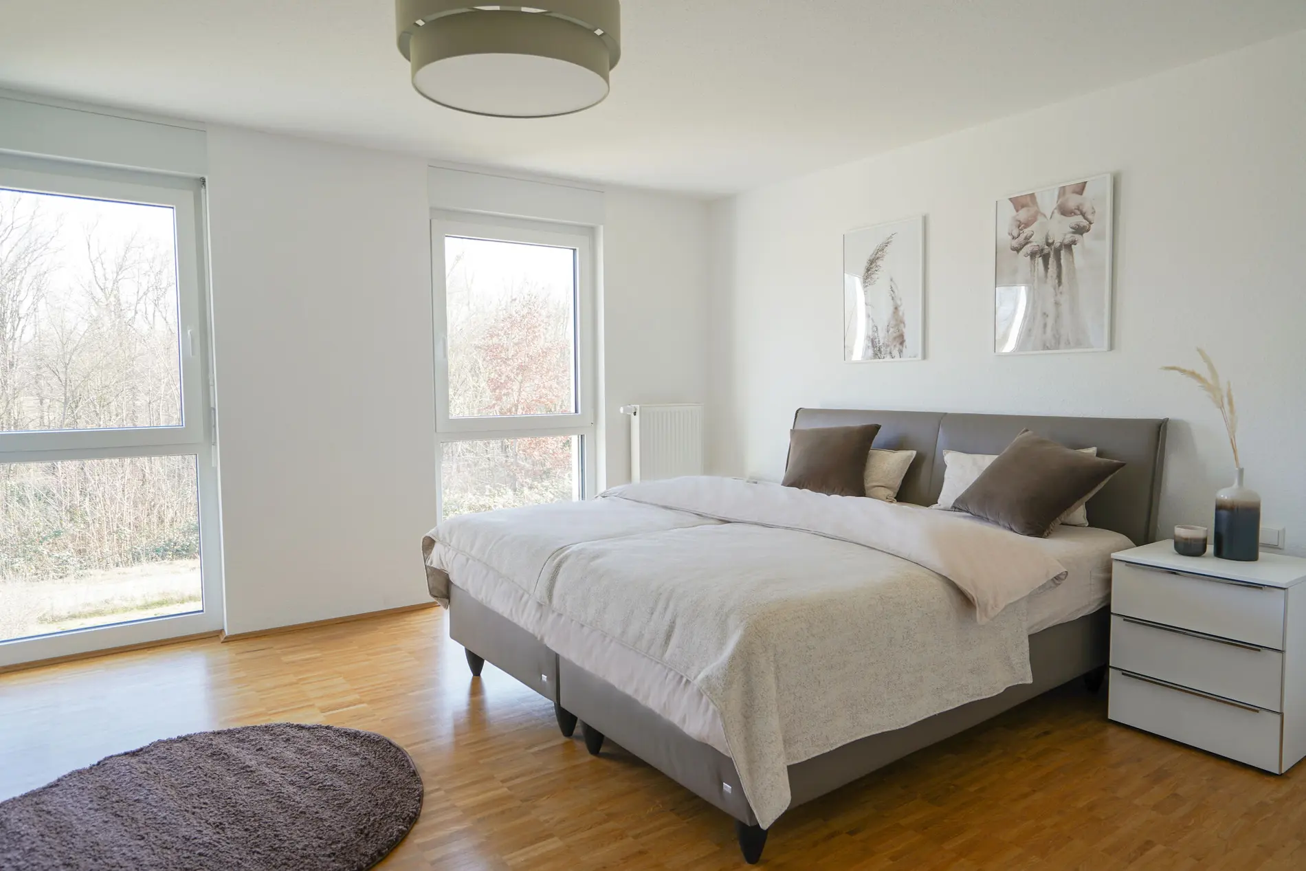 Schlafzimmer-Doppelbett-Musterhaus Ein Doppelbett mit braunen Kissen und einem Nachtisch