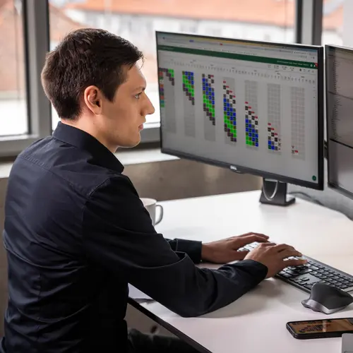 Die Abteilung Digitalisierung bei weisenburger Ein junger weisenburger Mitarbeiter arbeitet am Computer mit Terminplanungssoftware