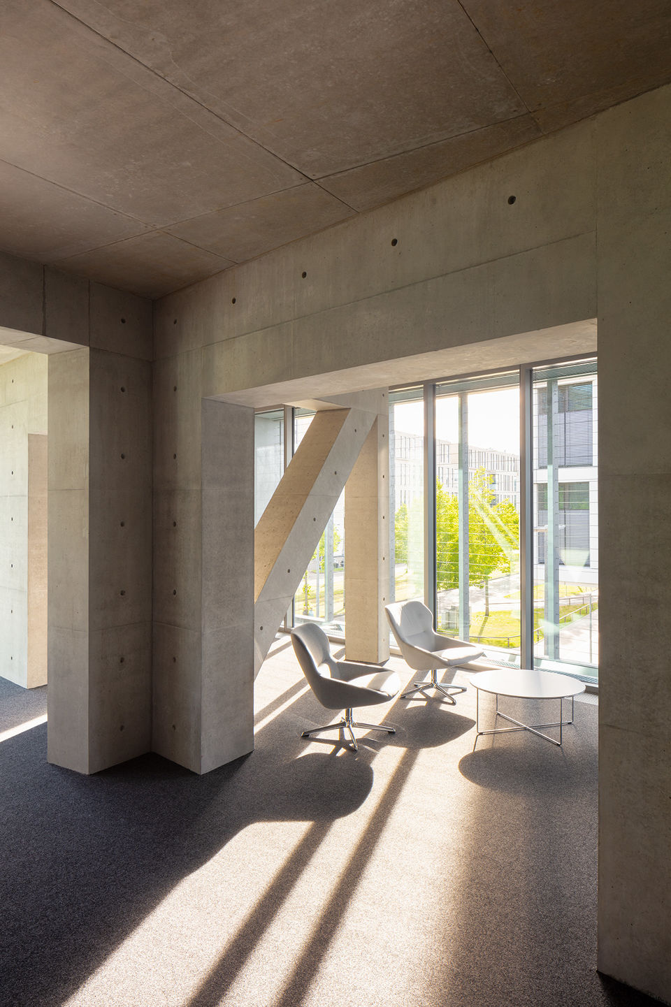 Licht fällt durch die Fenster auf eine gemütliche Sitzgruppe umgeben von einer Fachwerkkonstruktion.