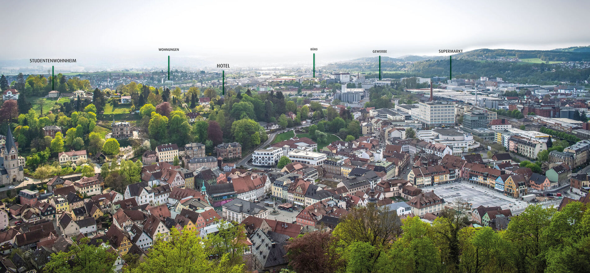 Drone image of a village with a forest around it