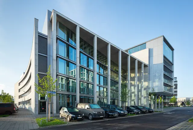 Nord-West Ansicht von der weisenburger Zentrale © HGEsch weisenburger-Team Nord-West Gebäudeansicht mit geparkten Autos vor dem Gebäude