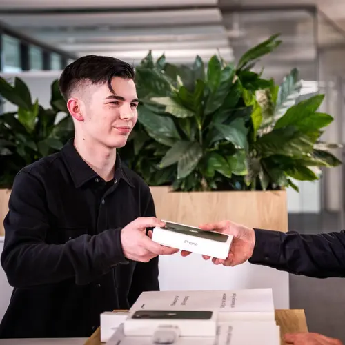 Systemadministrator bei weisenburger Systemadministrator übergibt iPhone an weisenburger-Mitarbeiter