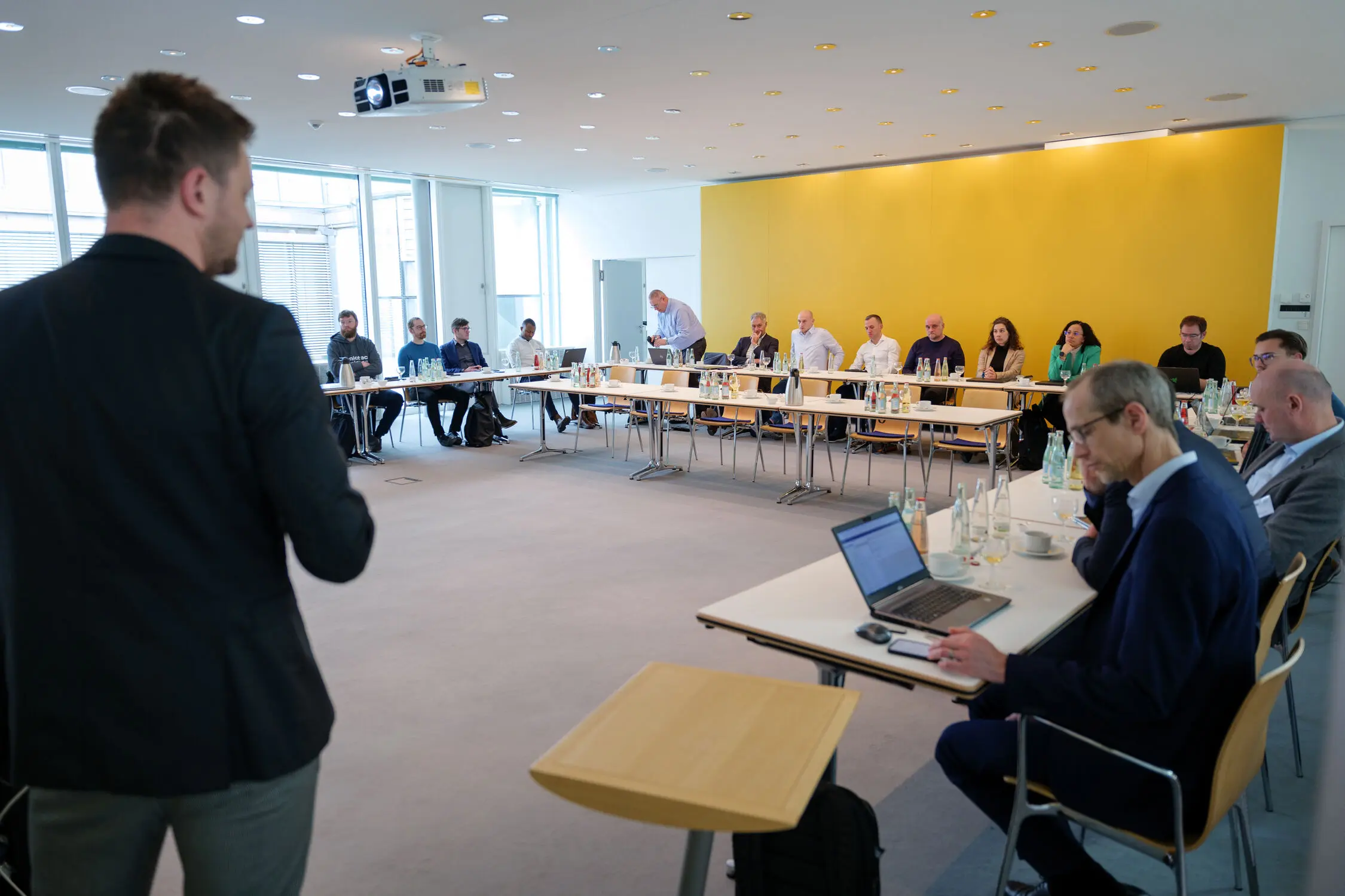 Versammlung beim weisenburger Lean KickOff 2024 In einem Besprechungsraum wird ein Vortrag von einem Mann gehalten und viele Mitarbeiter hören zu