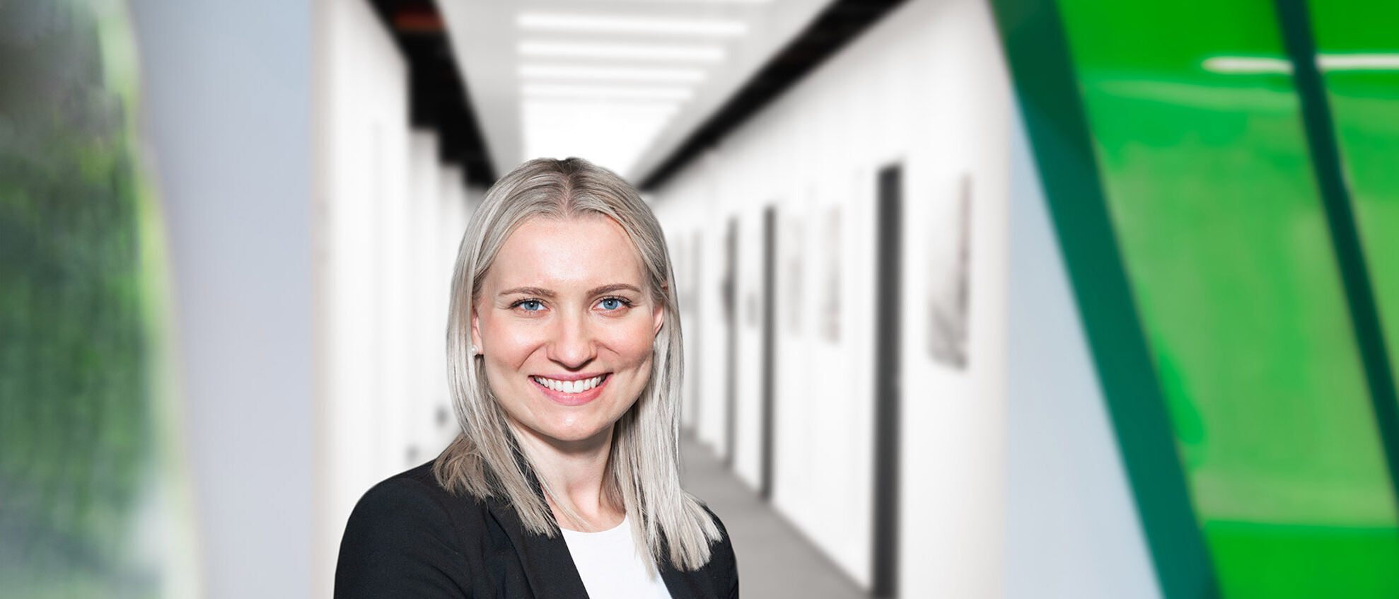 Eine Frau im Bemusterungszentrum schaut in die Kamera und hat ein Tablet in der Hand