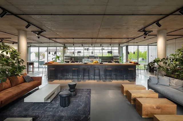 Cafeteria der weisenburger Zentrale mit Ansicht auf die Theke © HGEsch Theke und Küchenzeile in der Cafeteria von der weisenburger Zentrale mit Sitzmöglichkeiten und vielen Pflanzen