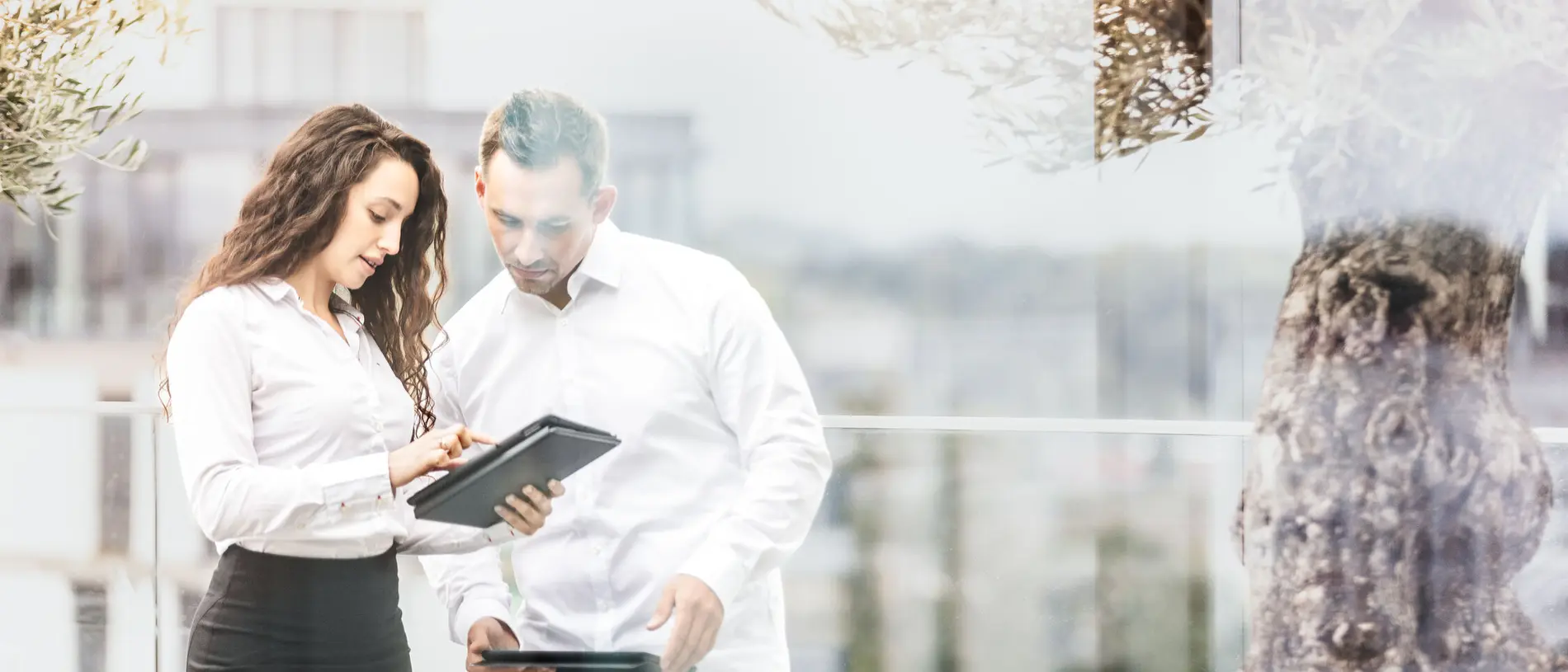 weisenburger Projektplanung mit Tablet Eine Frau und ein Mann stehen auf der weisenburger Dachterrasse und schauen zusammen in ein Taplet