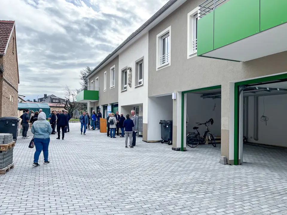 Key handover of new residential building Speyer Maikammer Key handover of an apartment building with gray paint and green balconies