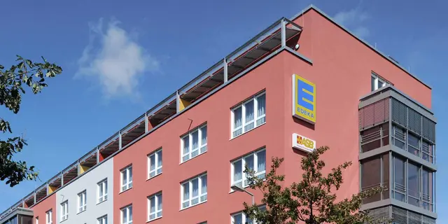 Gewerbeeinrichtung-Edeka-Karlsruhe Außenansicht Teil eines weisenburger Gewerbeeinrichtung mit roter Hausferssade