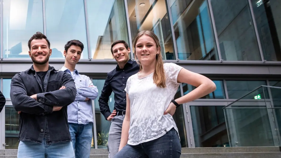 Studenten und Auszubildende bei einem Foto-Shooting Drei junge Männer und eine junge Frau stehen im Innenhof der weisenburger Unternehmenszentrale